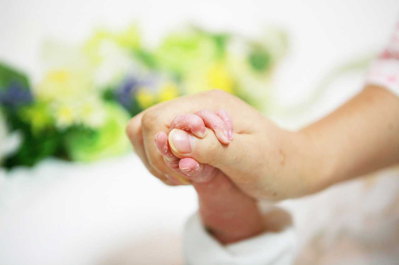 赤ちゃんの手を握る